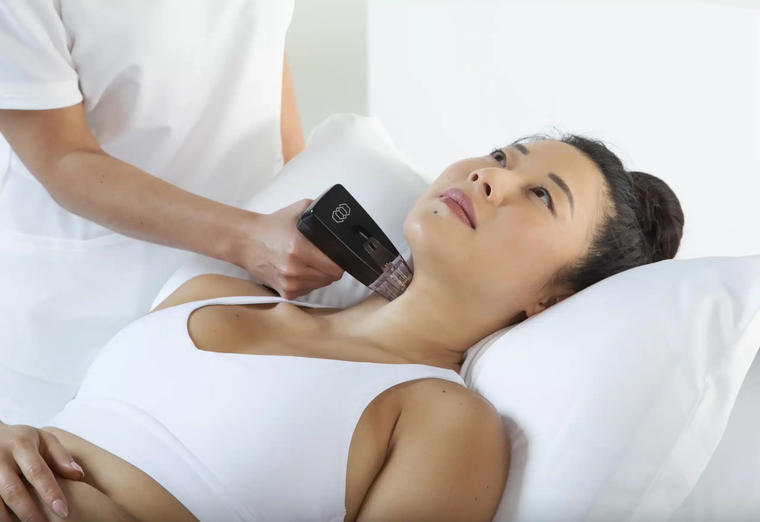 A woman getting her neck treated by a med spa provider using the Morpheus8 hand piece.